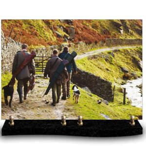 Plaque funéraire personnalisée avec photo de trois chasseurs avec leurs chiens, marchant le long d'un mur de pierres sèches. Hommage à la chasse en groupe et à l'amitié.